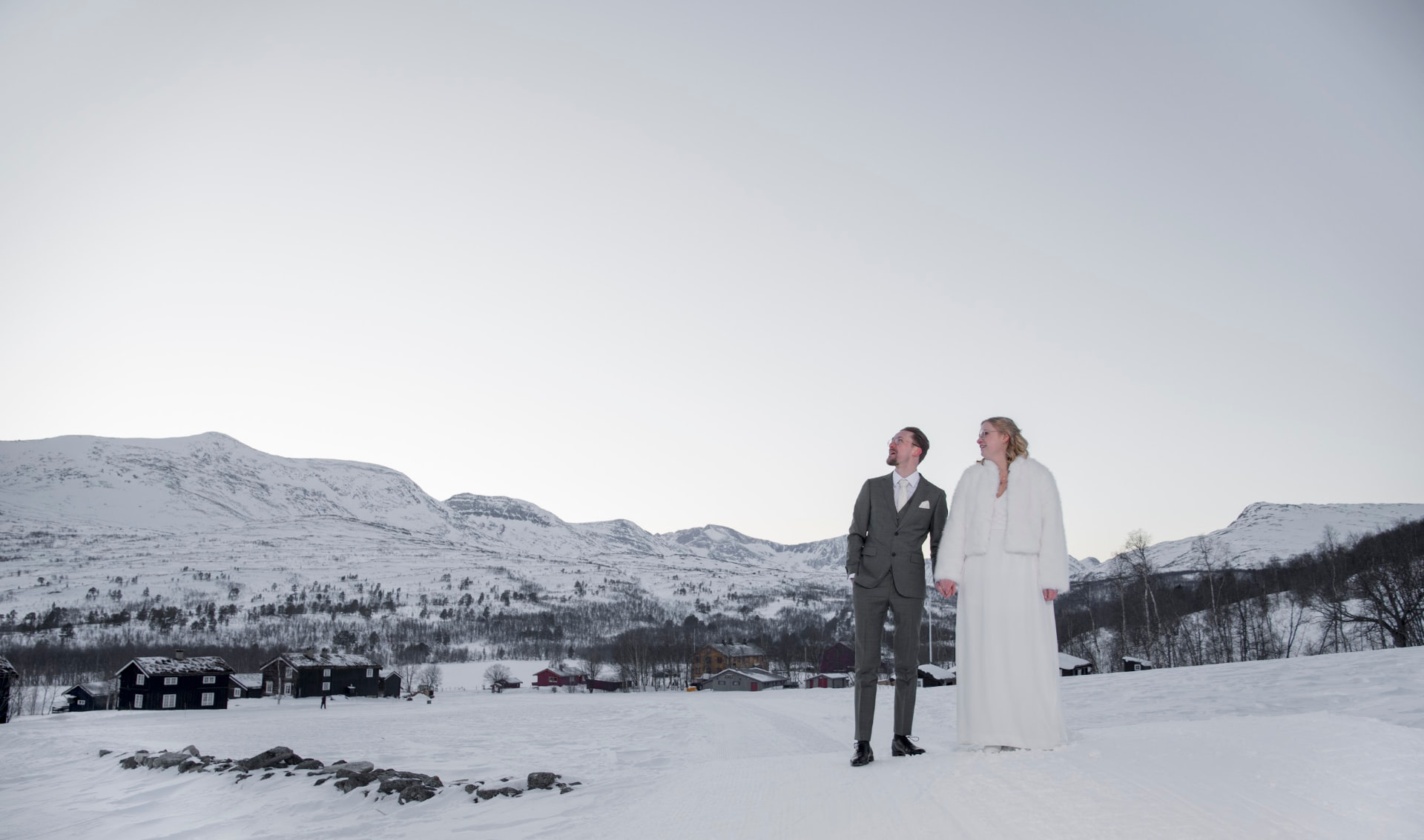 Brudepar i hånd i vinterlandskapet